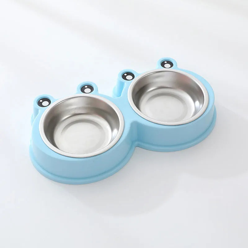Blue stainless steel frog-shaped double pet bowl for food and water on a floor.