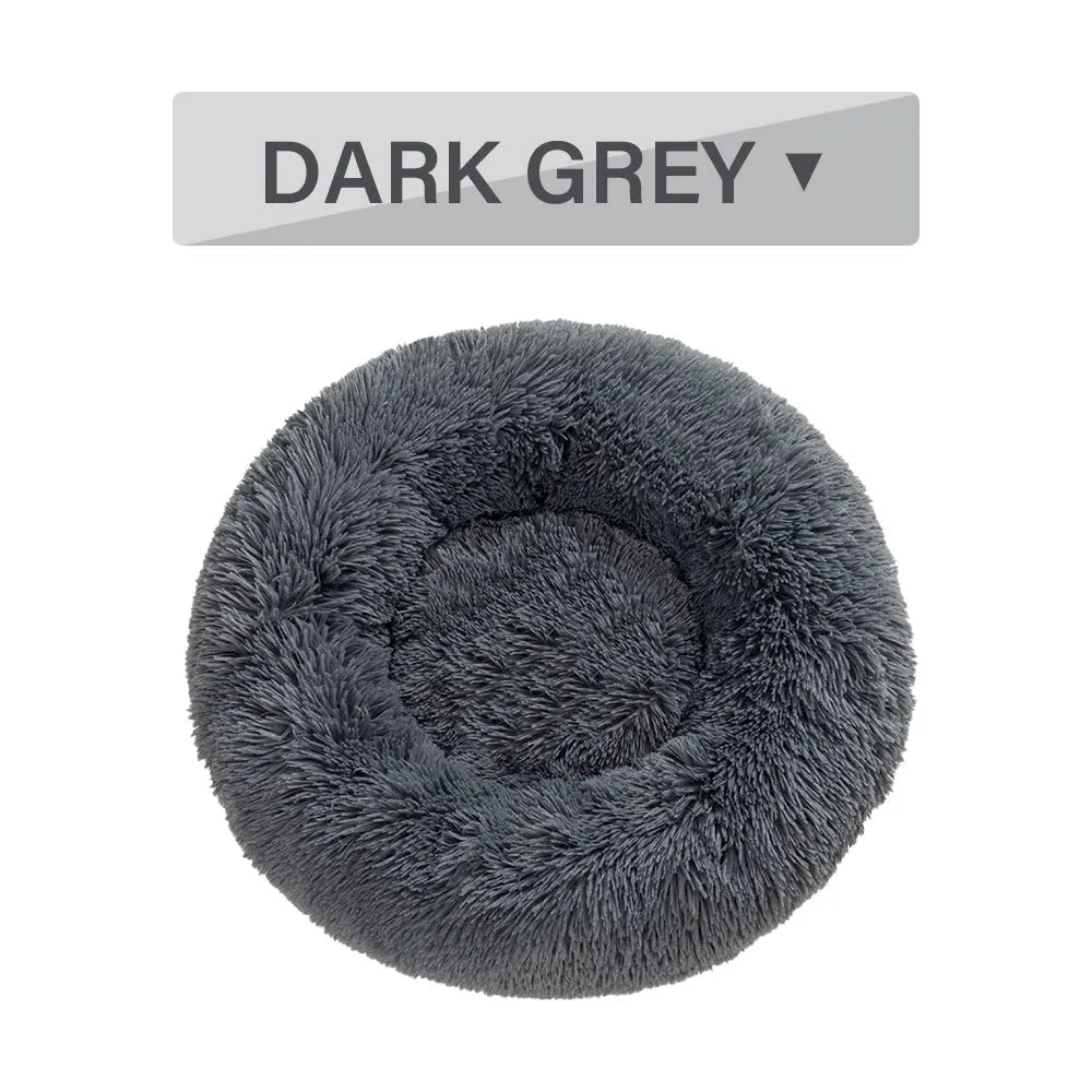 Fluffy donut-shaped dog bed in light grey plush material, showing raised rim and central cushion.