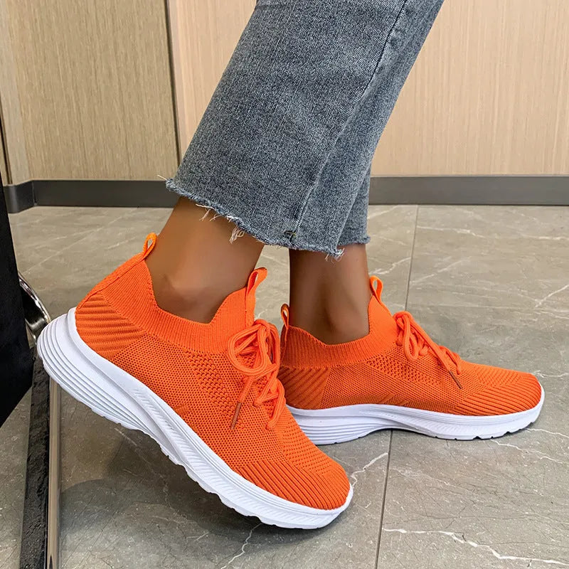 Women's mesh running shoes in creamy white with Flyknit upper and rubber sole