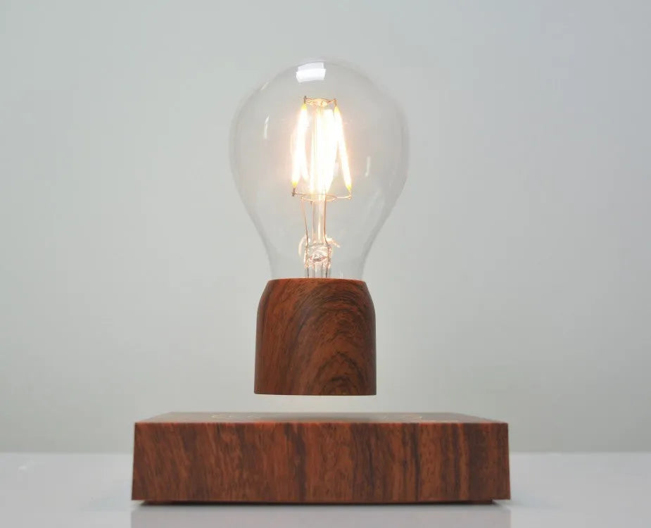 Magnetic levitation floating light bulb hovering above a wood-effect base.