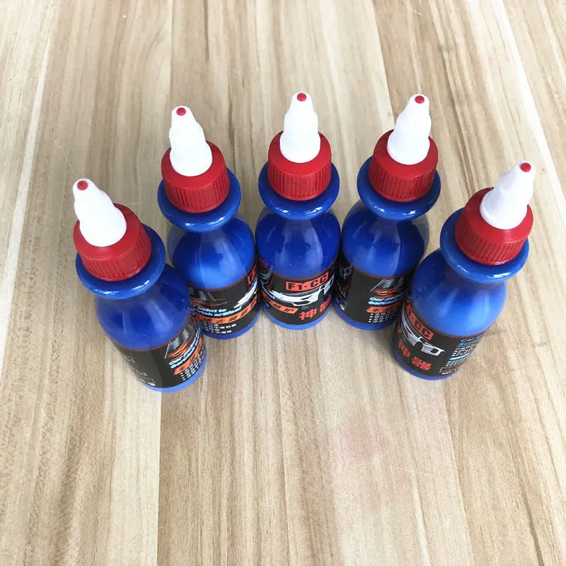 Small blue car scratch repair agent bottle with application tool for automobile bodywork