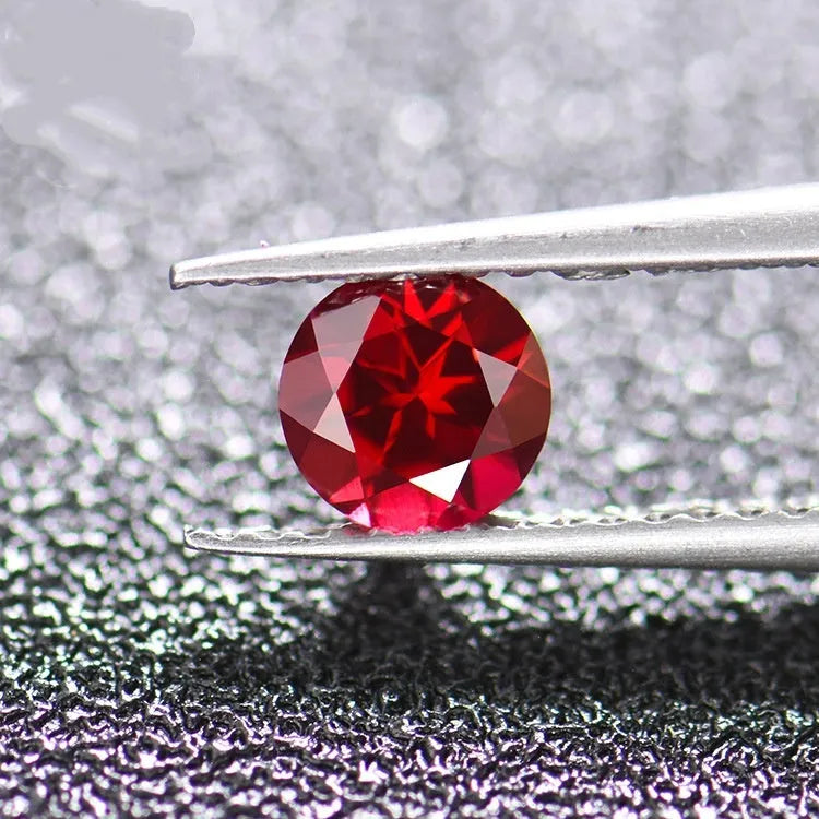 Cultivated ruby gemstone in various cuts including round, princess, oval and pear shapes on white background.