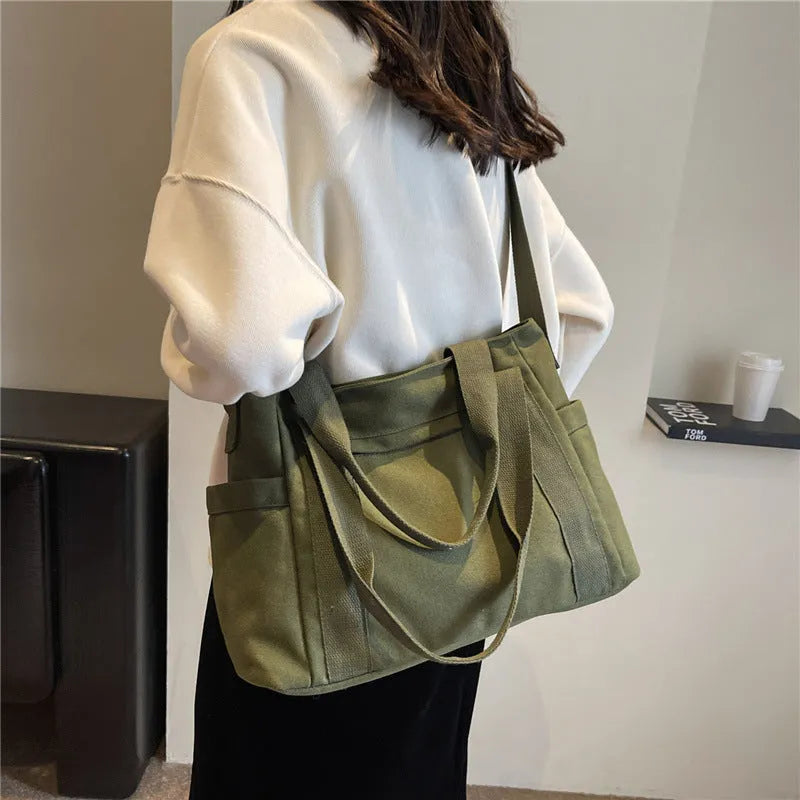 Women's large capacity canvas shoulder bag in solid colour with outer pocket and internal phone compartment