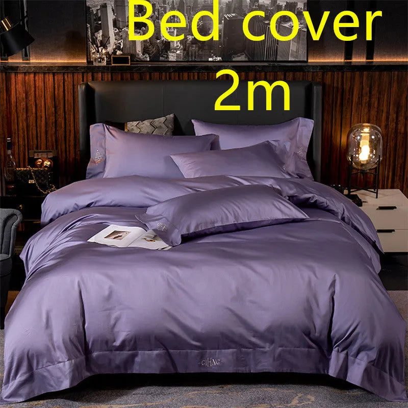 Four-piece cotton satin quilted bedding set with duvet cover, sheet, and pillowcases in a bedroom setting