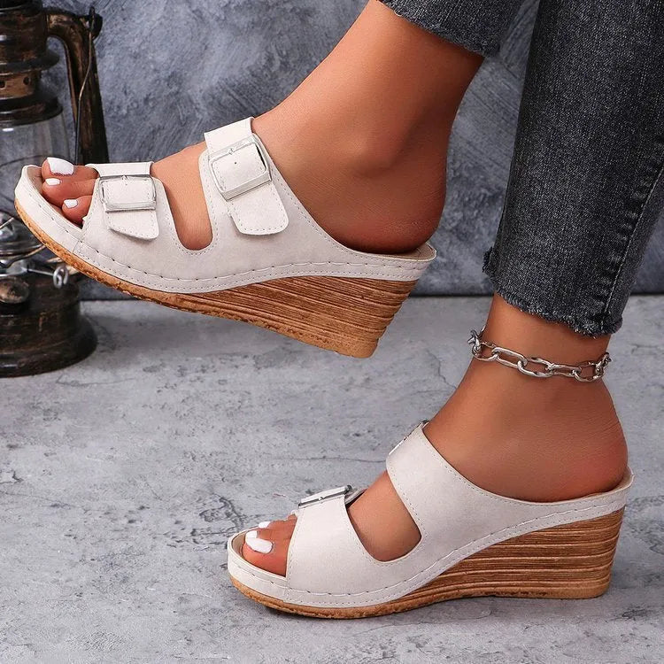 Women's creamy-white wedge slippers with a decorative outer buckle on the PU upper and a rubber sole.