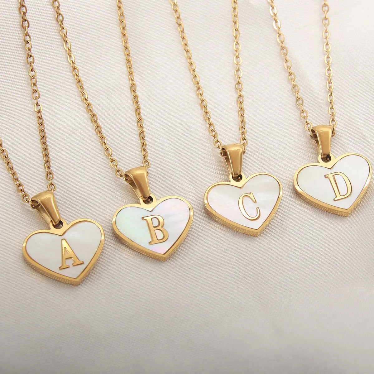 Gold plated chain necklace with a white shell heart-shaped pendant personalised with a single letter initial.