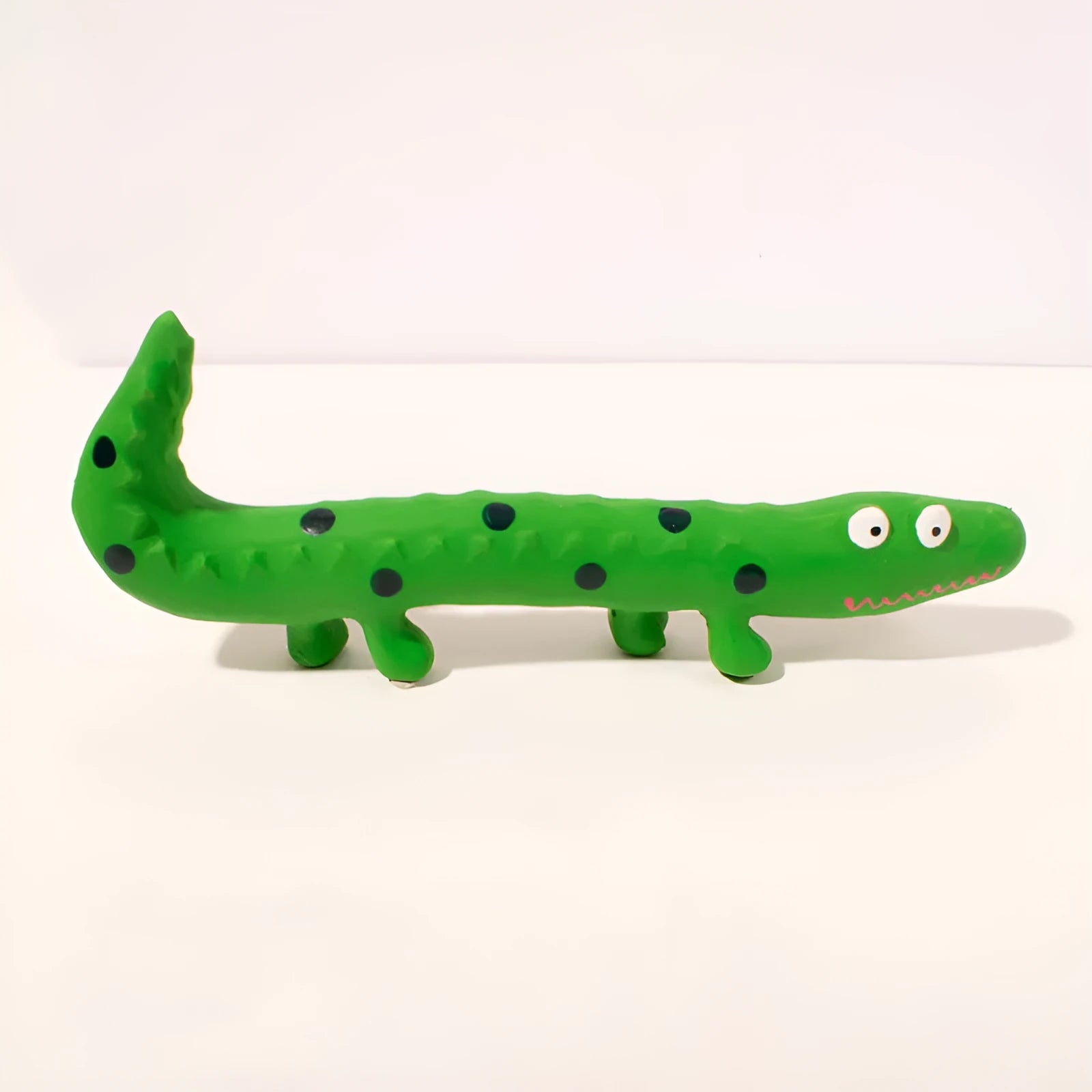 Green cartoon lizard shaped dog chew toy with squeaker on a white background.