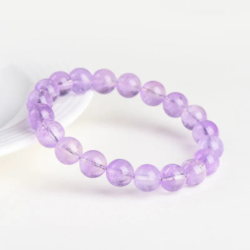 Lavender amethyst round bead bracelet with water ripple pattern on a table.