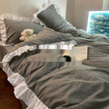 Washed cotton linen quilt cover bedding set in solid creamy colour on a bed.