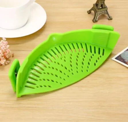 Silicone clip-on kitchen strainer with stainless steel filter mesh attached to a pot rim