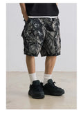Loose fit straight-leg denim shorts in black or army green on a hanger, showing mid-waist and zip fly detail.