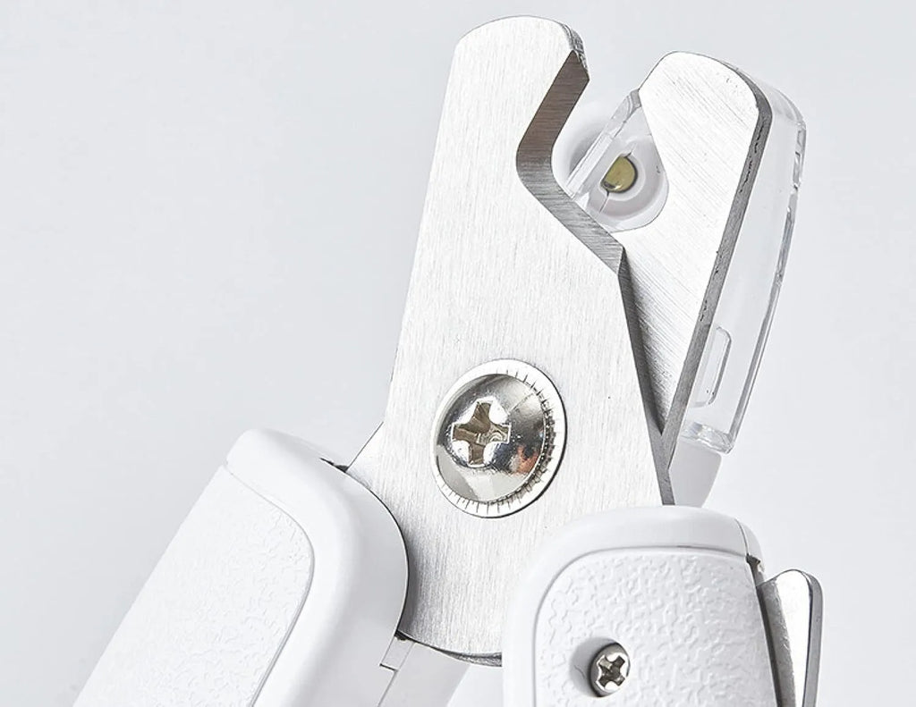 White pet nail clippers with LED light, transparent guard, triangular blades, and anti-slip handles for cat and dog grooming