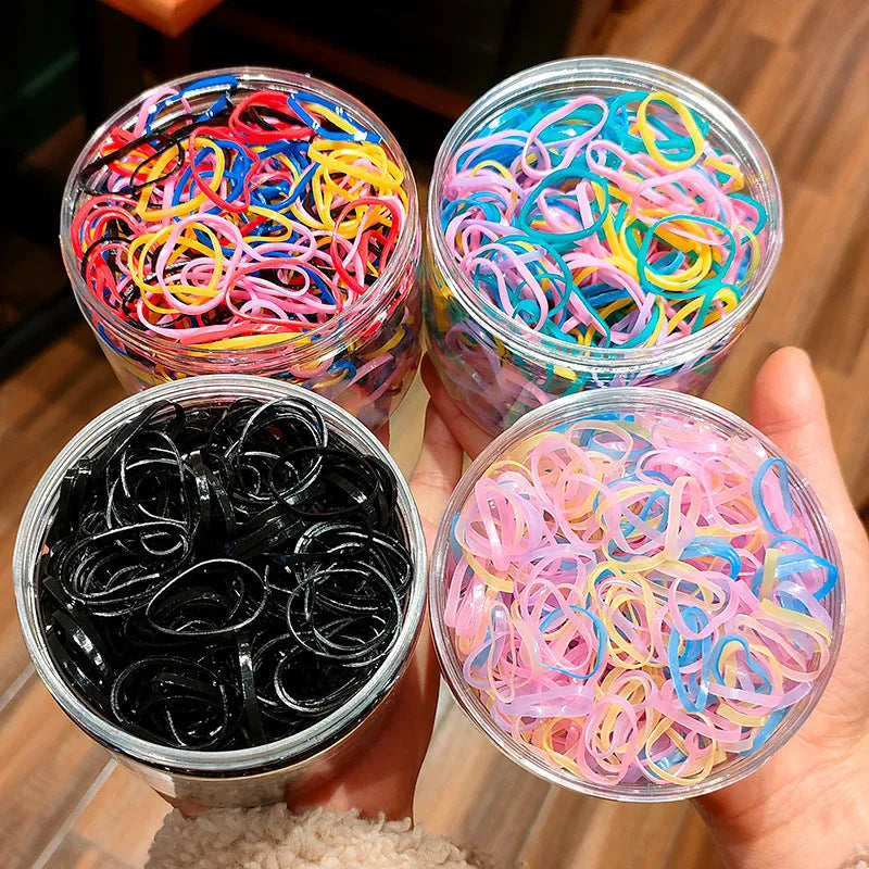 Multicoloured TPU baby hair ties in a reusable transparent storage container