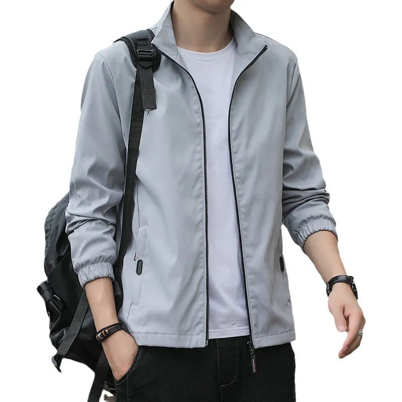 Man wearing a loose-fit Korean style casual jacket in blue, with zip-up front and pocket detail.