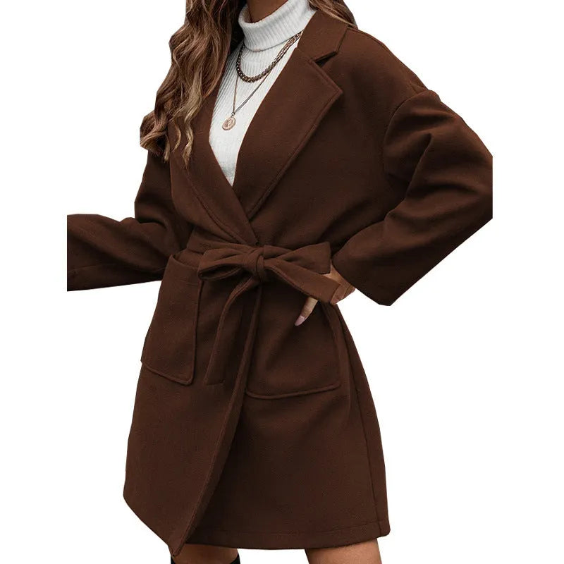 Long sleeve brown lapel button coat with belt and split back, loose fit on a hanger.