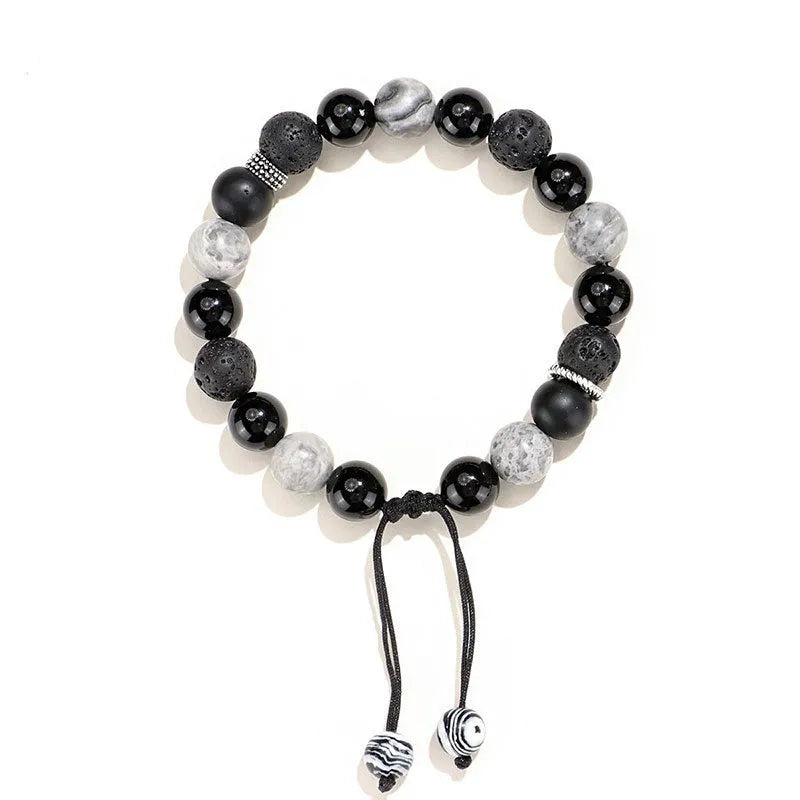 Black agate map stone volcanic rock bracelet with diamond-shaped cuts on wrist.