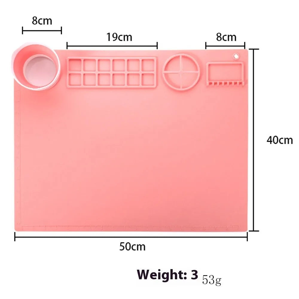 Light blue silicone painting mat with two round bowls, measuring 50cm by 40cm, on a wooden table.