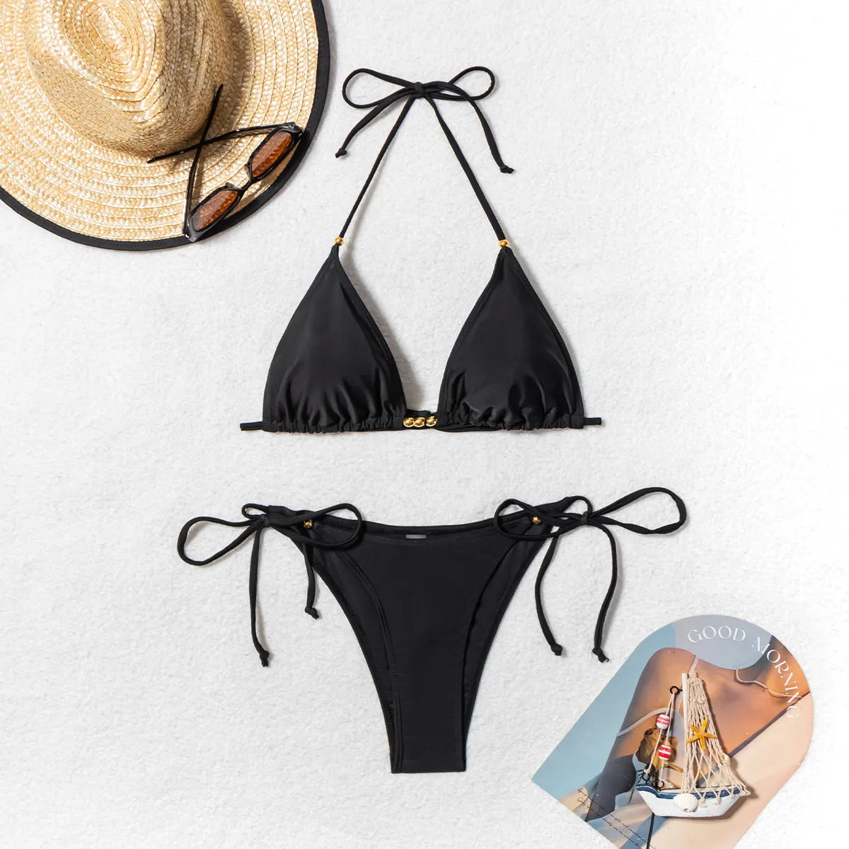 Black women's bikini swimsuit with metal bead decoration on a split design.