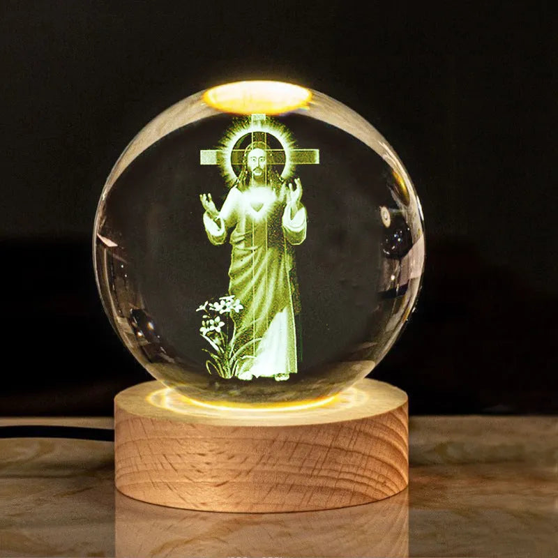 White crystal decorative ball with cross scenes on a wooden warm light base.