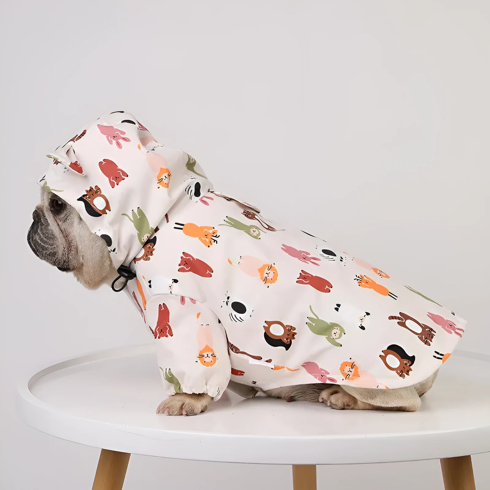 Beige dog raincoat with cartoon animal design showing waterproof PU construction