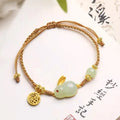 Hetian jade geometric rabbit charm bracelet on a yellow string for women.
