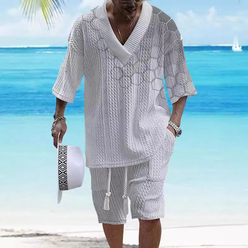 Man wearing a printed drop-shoulder knitted short-sleeved top with matching shorts in a solid colour.
