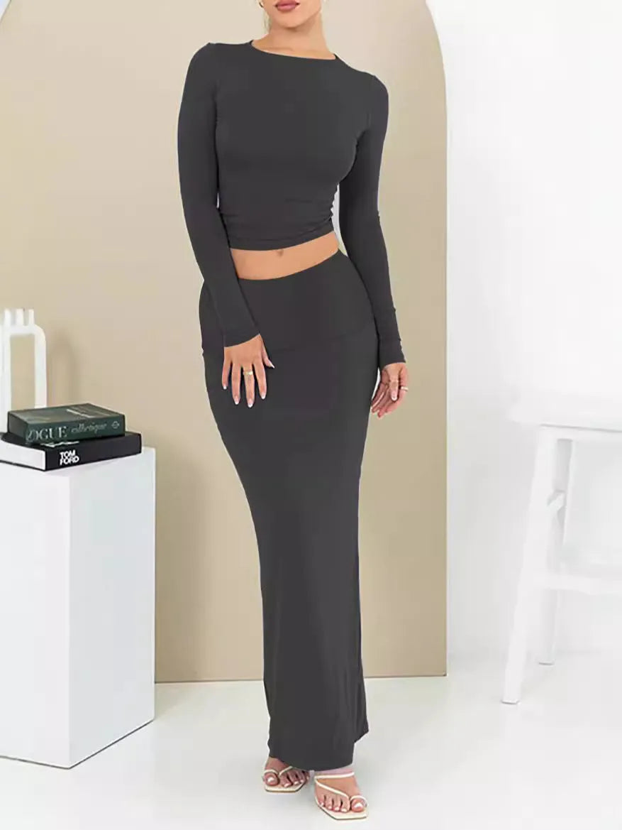 Women's black two-piece suit set with three-quarter sleeve top and long skirt on a mannequin.