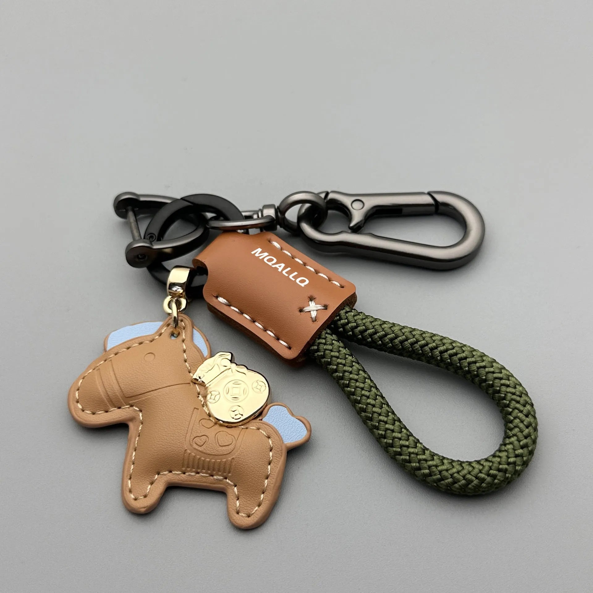 Handmade brown cowhide key ring pendant with a zinc alloy pony belt buckle and green flanelle rope.