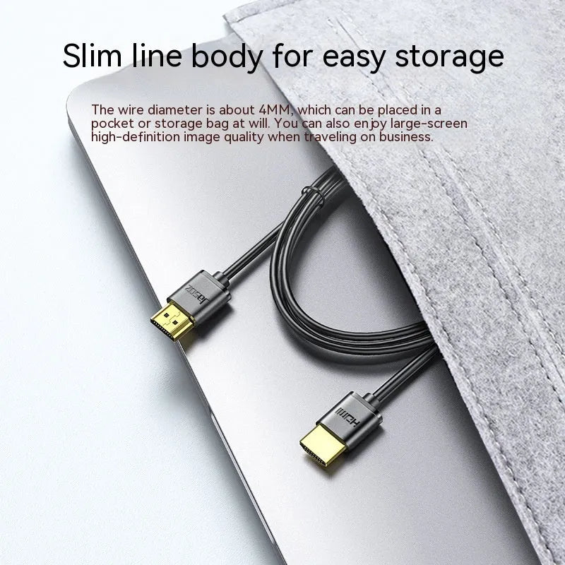 Close-up of a black HDMI cable with gold-plated connectors and a flexible cord on a grey background.