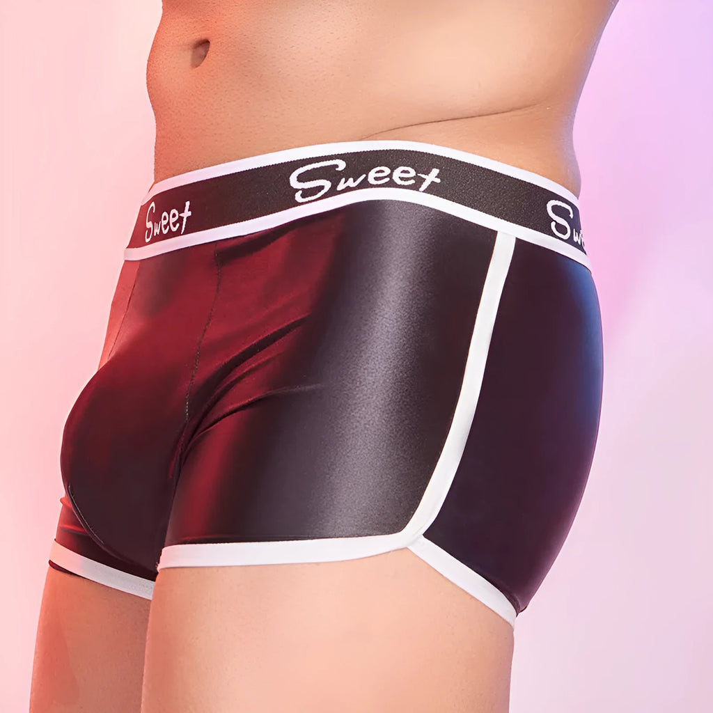Man's shiny silky nylon boxer briefs in black, white, and sapphire blue colours laid flat.
