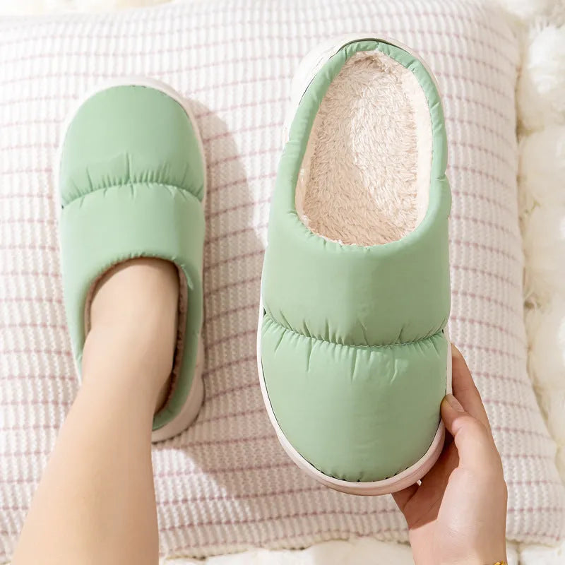 A pair of thick-soled indoor slippers with an artificial leather upper and soft plush lining, shown in a choice of colours.
