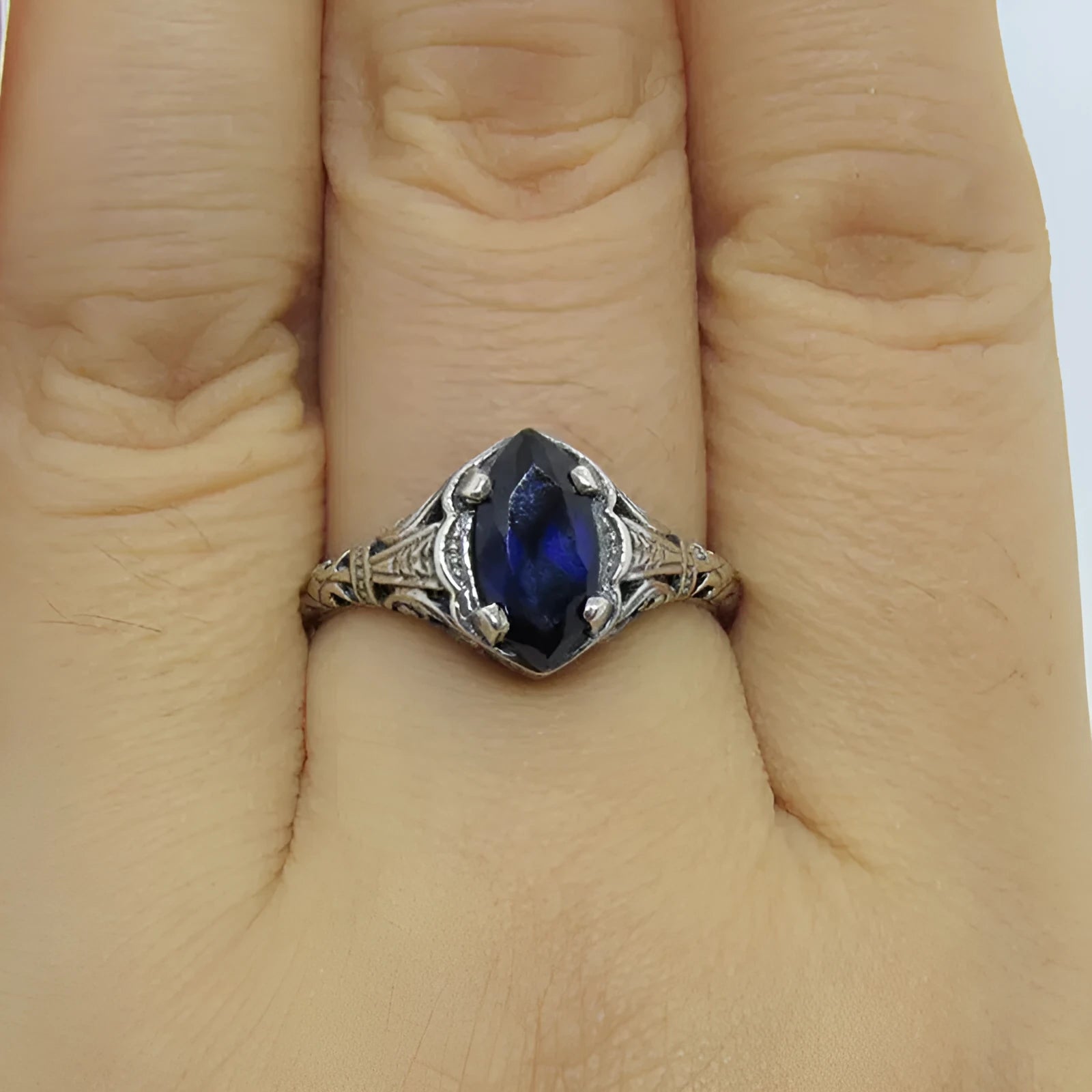Silver geometric hollow alloy women's ring on a grey background