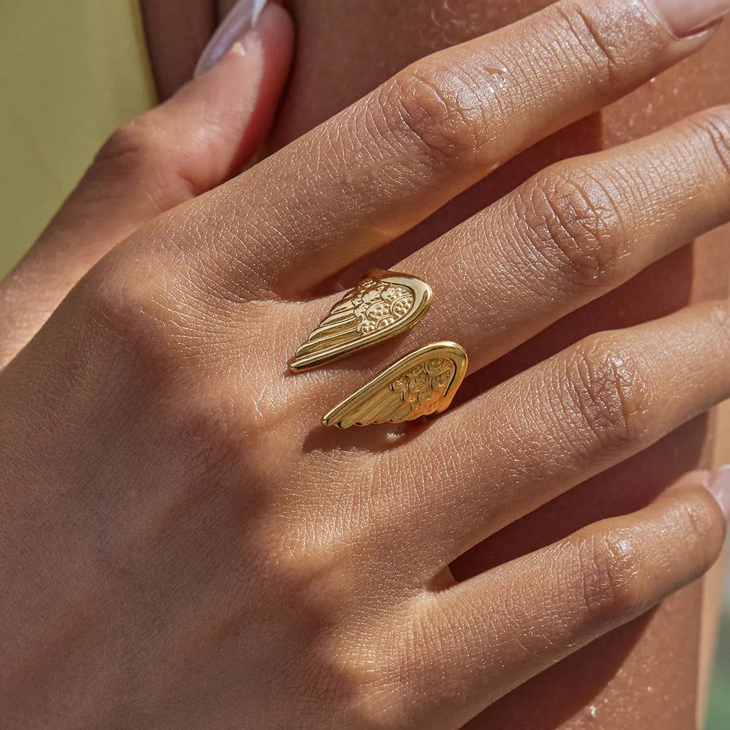 Silver wing design adjustable ring on hand showing opening mechanism