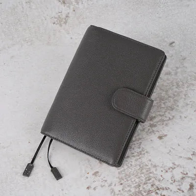 Close-up of a lychee pattern head layer cowhide A6 loose-leaf diary in off white, showing textured cover and ring binding