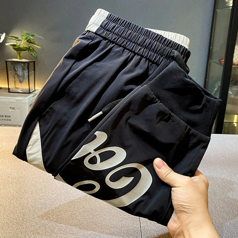Man modelling black ultra-thin ice silk ankle banded casual cropped trousers.