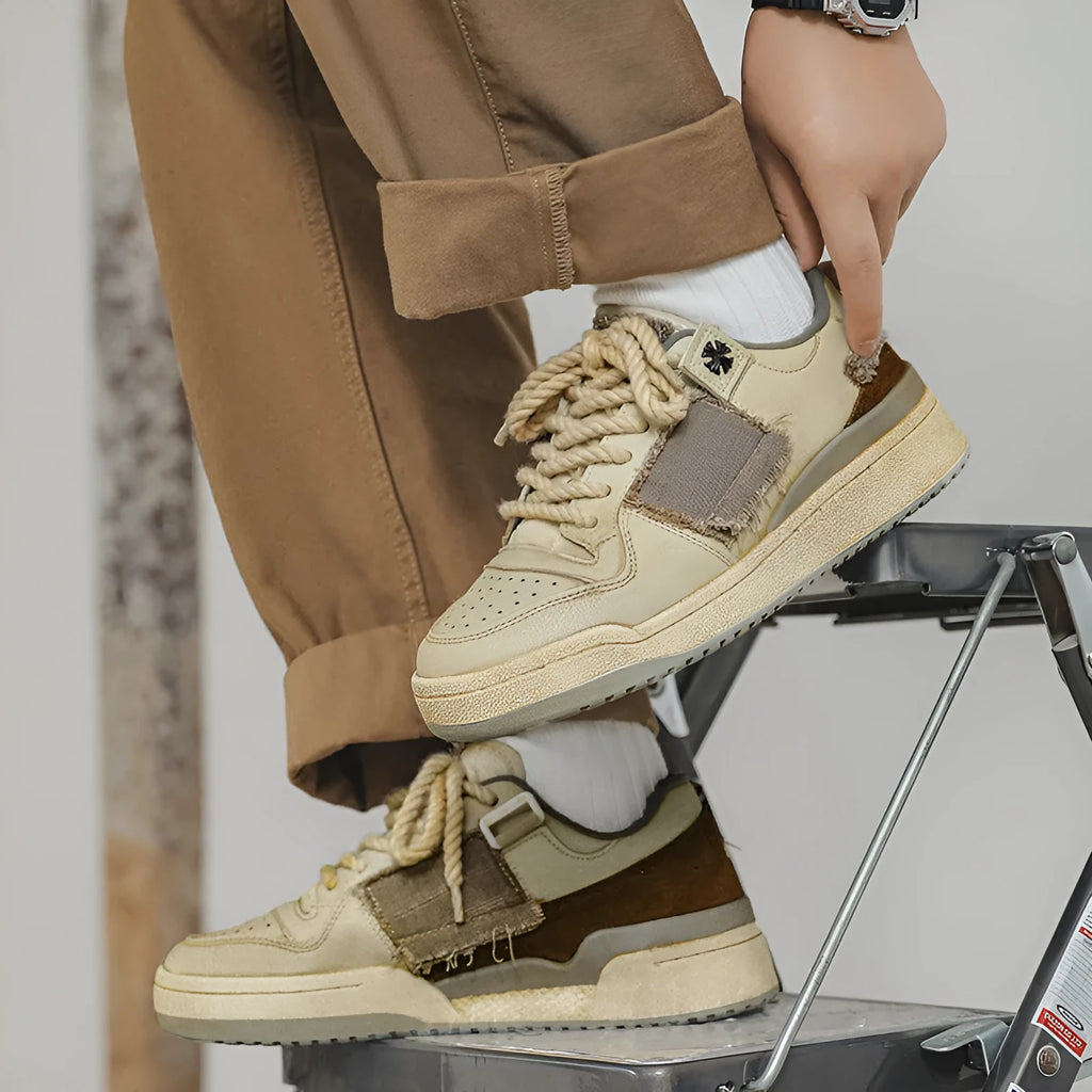 Beige vintage style low top skateboard shoes with flat rubber sole and lace-up front.