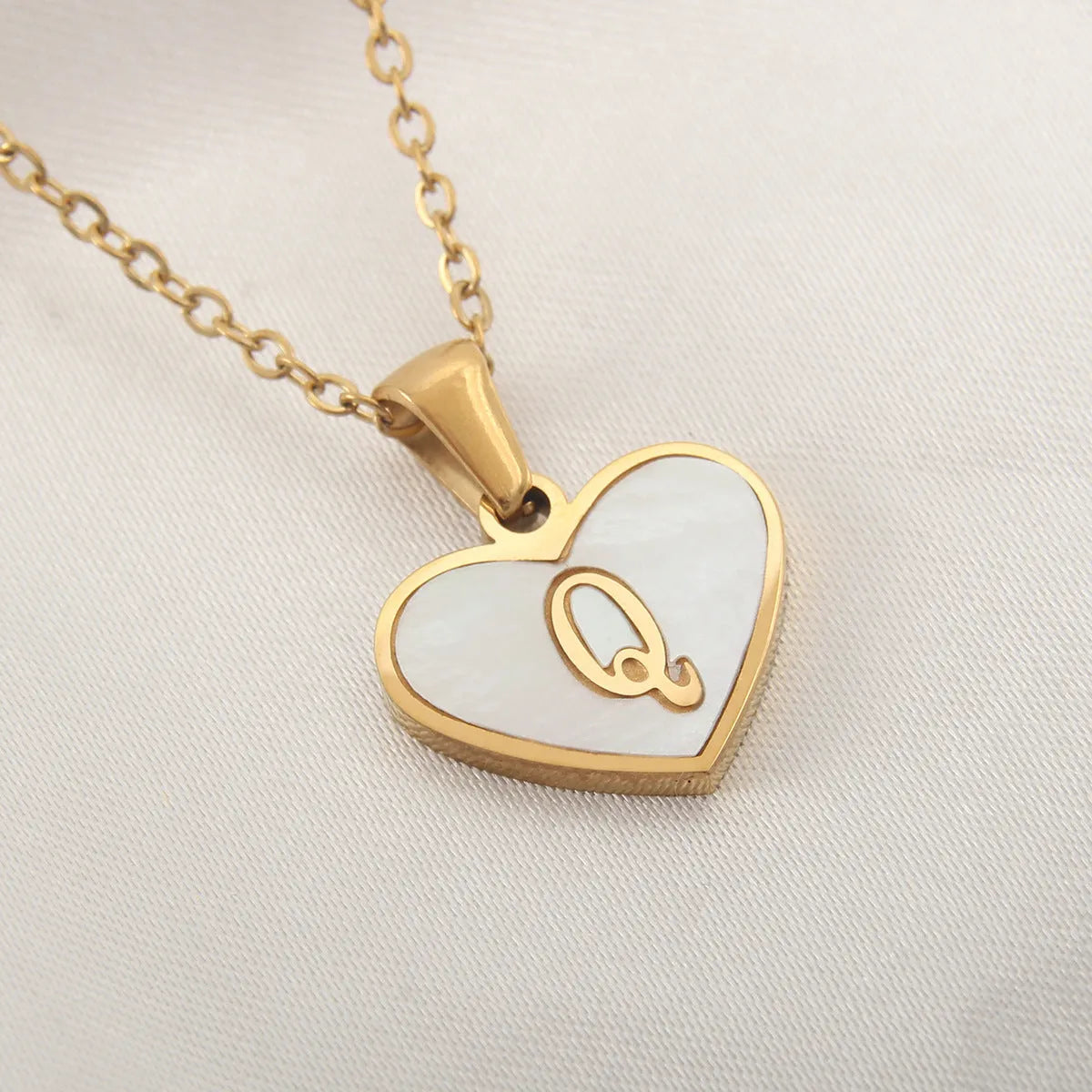 Gold plated chain necklace with a white shell heart-shaped pendant personalised with a single letter initial.