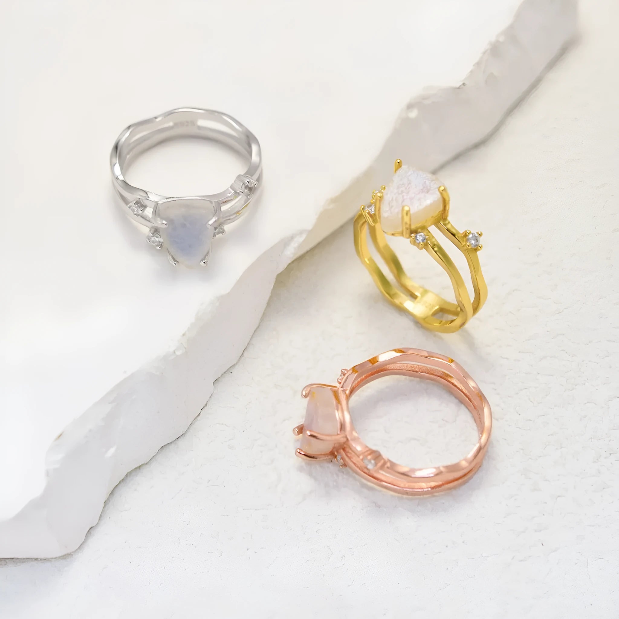 S925 silver geometric ring featuring an irregular triangle design with a moonstone, shown in rose gold, white gold, and yellow gold finishes.