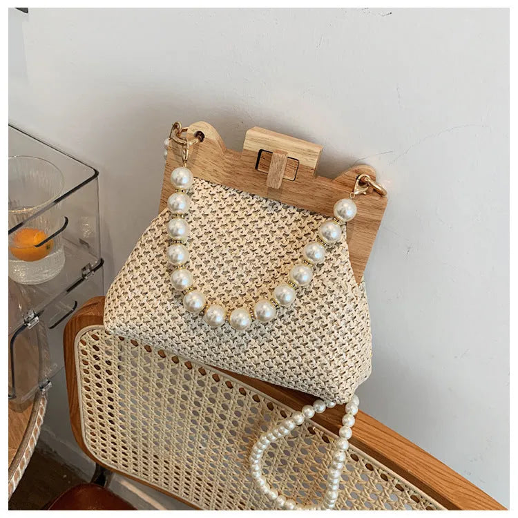 Women's straw shoulder bag with woven pearl chain detail and multiple internal compartments