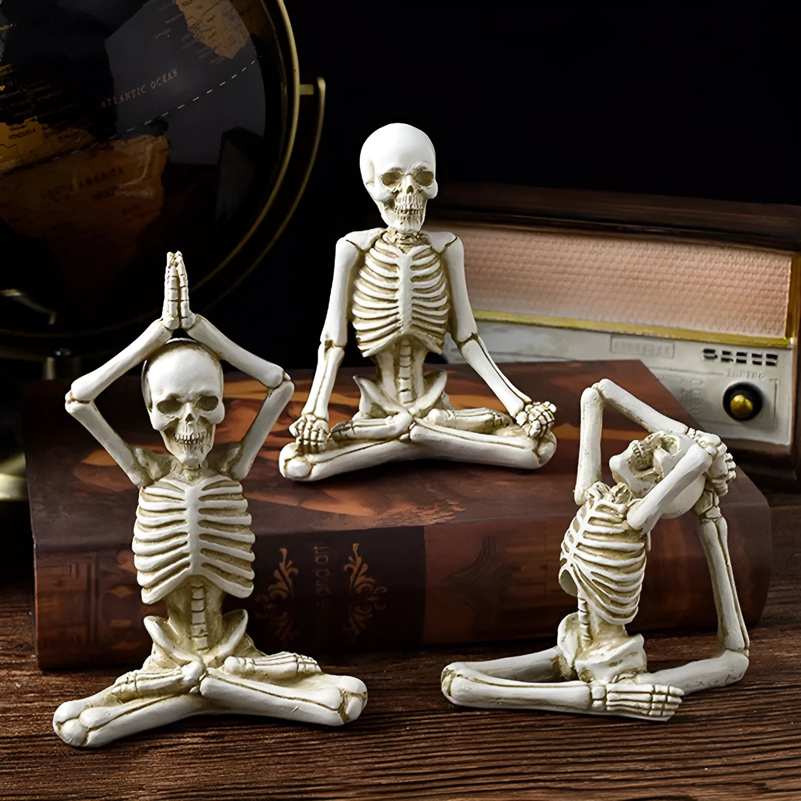 A detailed resin desktop ornament of a yoga-pose skeleton skull in black and white colour options.