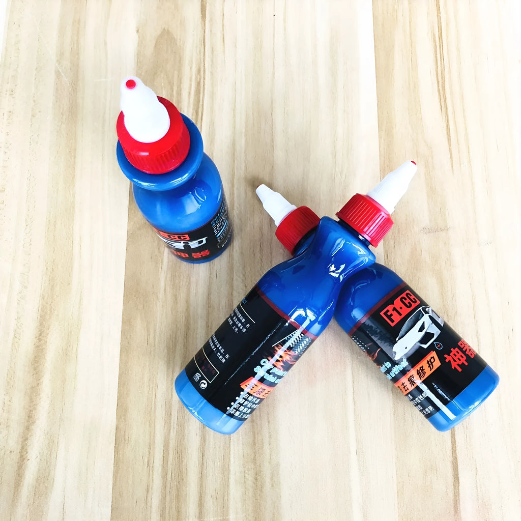 Small blue car scratch repair agent bottle with application tool for automobile bodywork