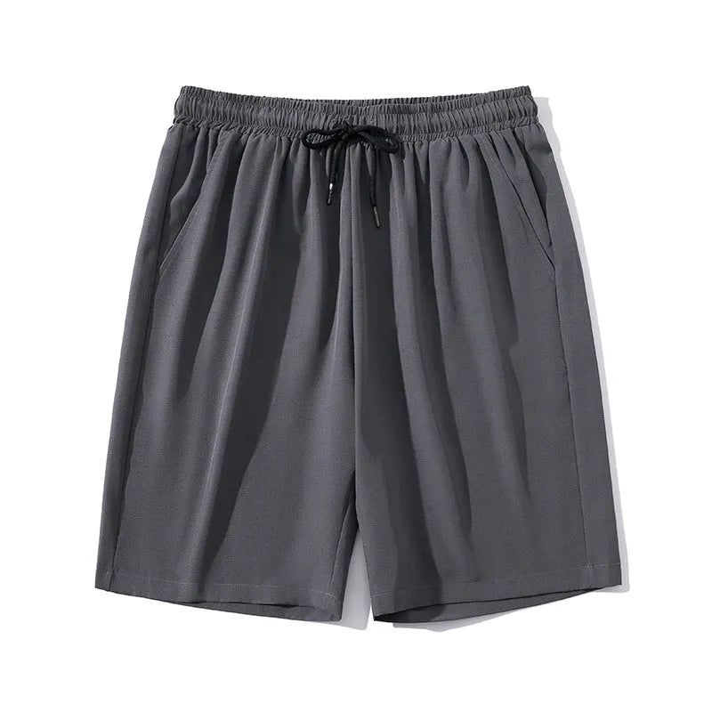 Man wearing cropped black nylon sports pants with a straight cut and elastic waist for summer.