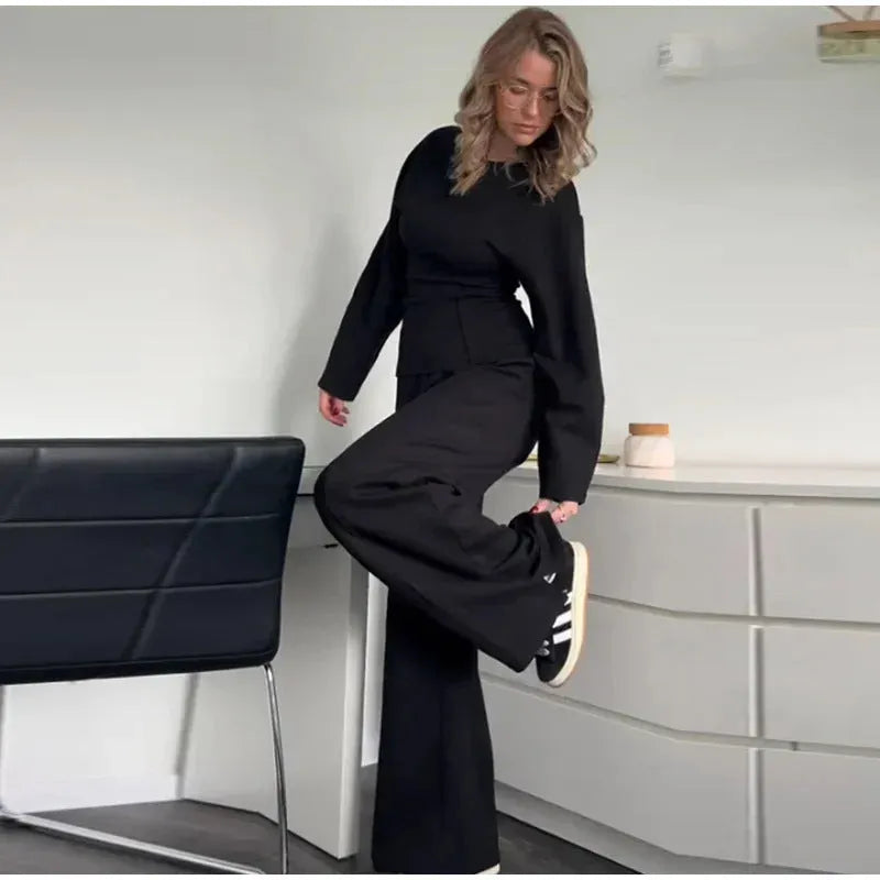 Women's black polyester pleated top and wide leg trousers suit set on a hanger