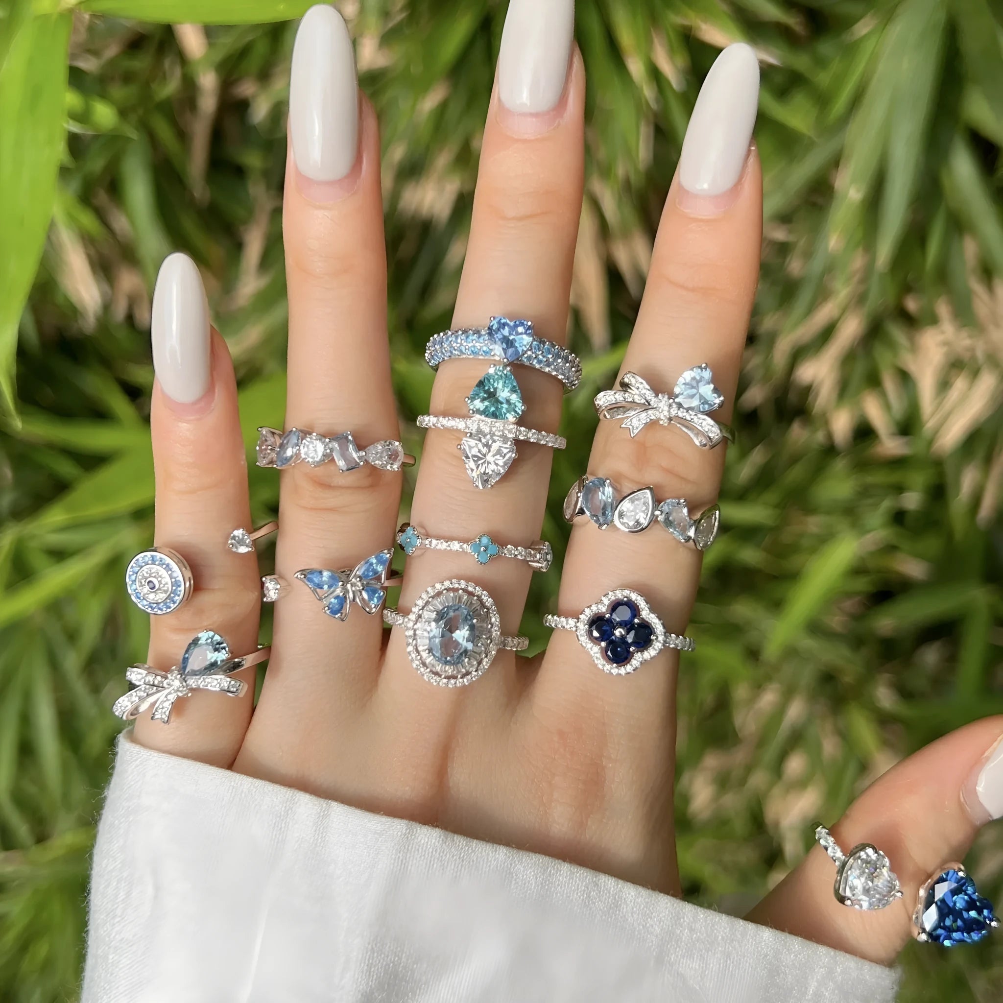 Women's S925 sterling silver ring with sea blue zircon heart or bow shape on plain background