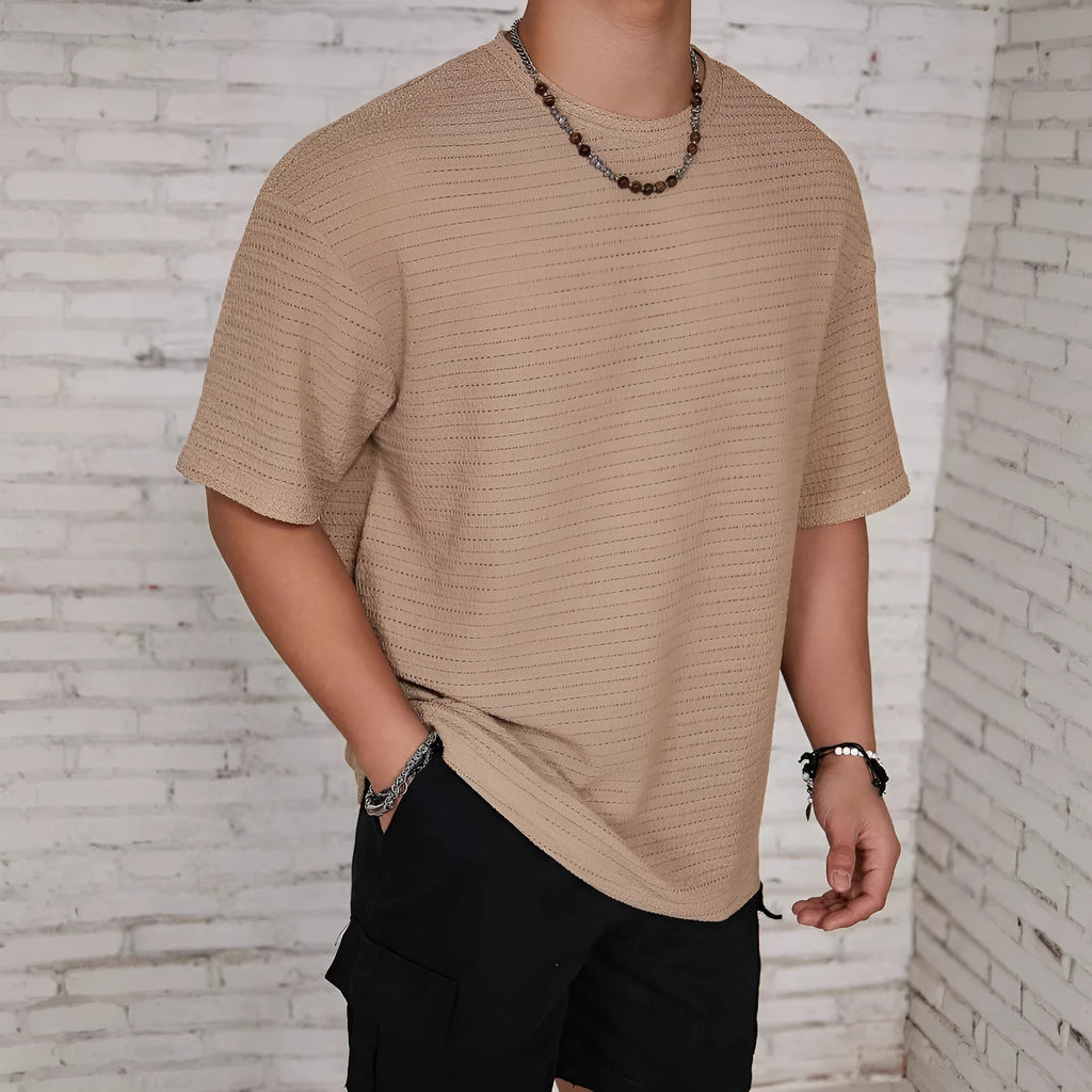 A man wearing a slim-fit, solid-colour, short-sleeve round neck T-shirt.