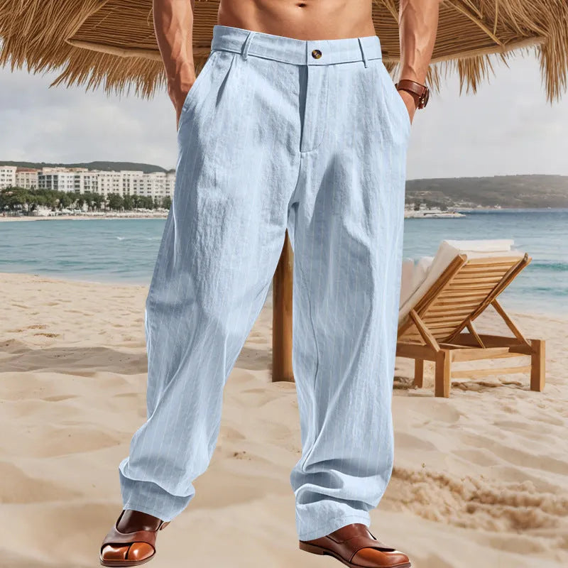 Man wearing straight-cut, high-waisted linen trousers with a wide leg and striped pattern in a light colour.