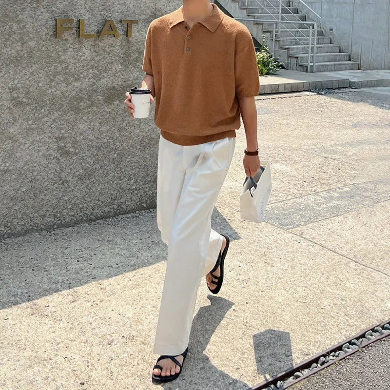 Man wearing a caramel coloured loose fit knitted polo shirt with short sleeves and an asymmetric design.