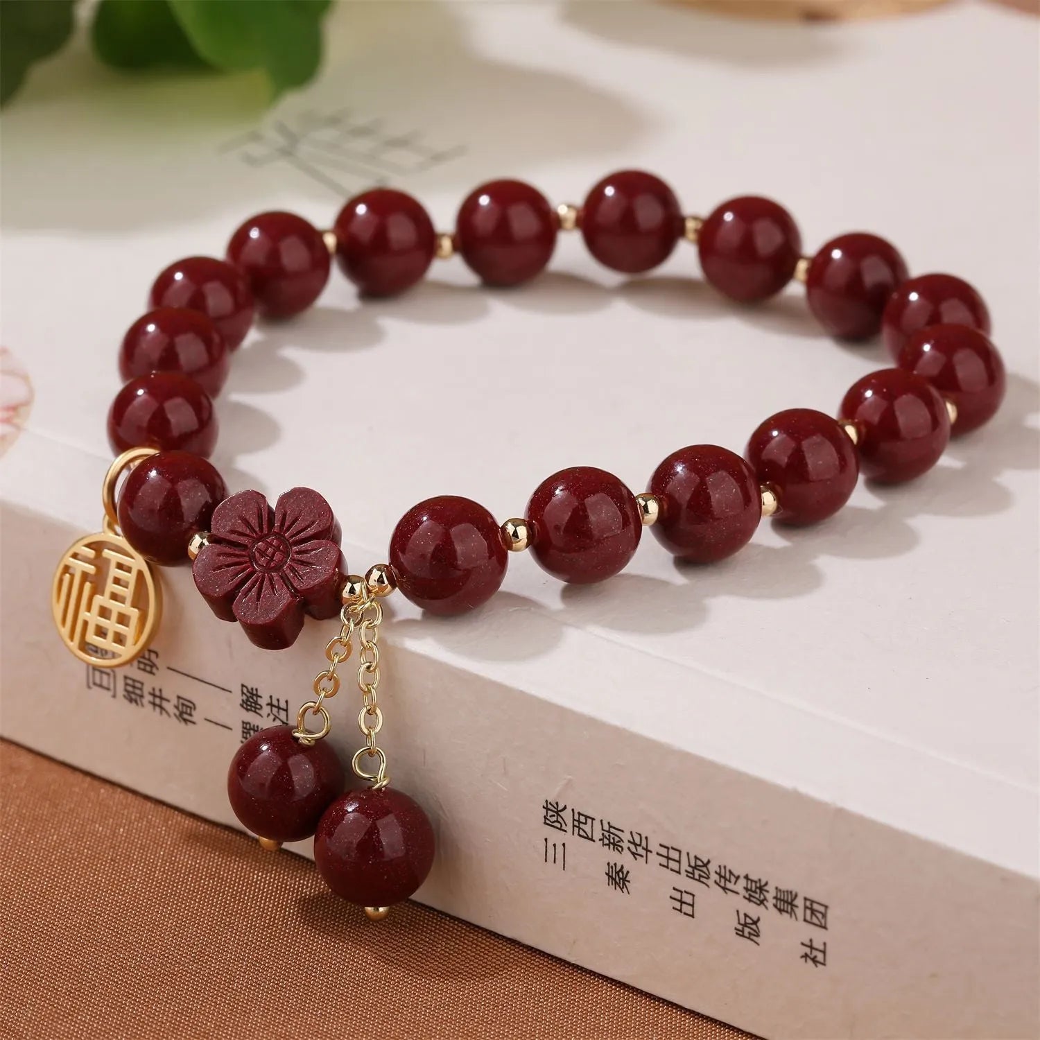 Close-up of a retro-style women's cinnabar bracelet with purple gold sand colour, showing fu character design and tassels.