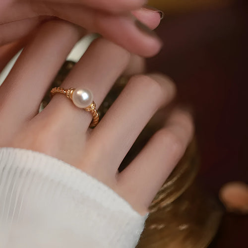 Adjustable antique twist design copper ring with pearl inlay in gold colour.