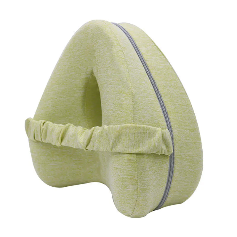 Heart-shaped dark blue jacquard memory foam leg pillow for adults on a bed.